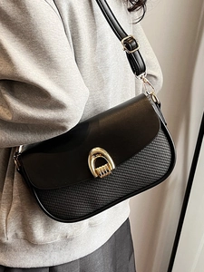 Minimalist black square crossbody bag with gold horseshoe buckle and woven texture