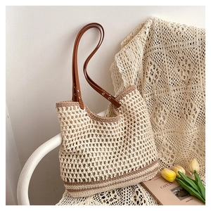 Close-up of woven tote bag showing the mesh texture and brown leather handle