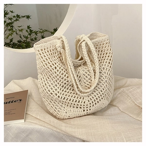 Detailed macro view of cream-white hand-woven net tote bag with sturdy braided handles