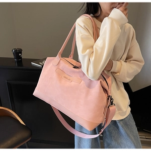 Detailed view of pink leather tote bag featuring NINGJIA branding and crossbody strap