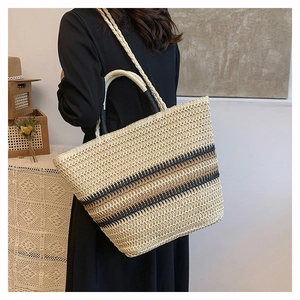 Detail showing handwoven striped tote bag with dual straps in a bohemian style