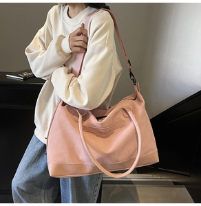 Detail of pink suede tote bag featuring NINGJIA embossed logo and wide shoulder strap
