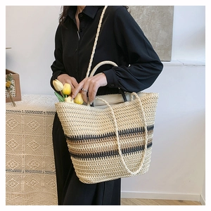 Detail of bohemian woven tote bag with brown stripes and dual handles in a cozy home setting