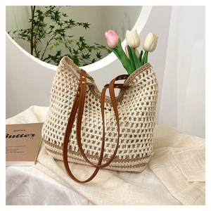 Detail of crochet tote bag with mesh hollow texture and slim brown leather straps