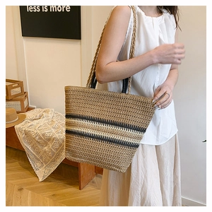 Detail of a large woven tote bag with stripe patterns and rustic rope shoulder straps