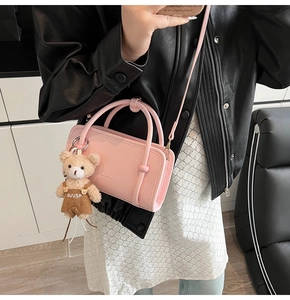 Pink PU leather square handbag detail with cute plush bear pendant shown on shoulder