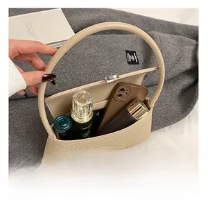 Vue détaillée de l'intérieur du sac tissé beige avec espace pour téléphone et maquillage
