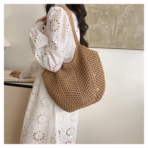 Detailed close-up of brown woven tote bag featuring intricate openwork crochet texture