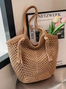 Handmade woven straw tote bag with boho tassels for beach vacation and summer travel
