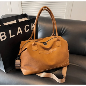 Detail of a large brown travel tote bag with NINGJIA logo and adjustable strap