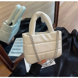 Detail of white quilted bucket bag with soft matte PU leather and silver ball chain strap
