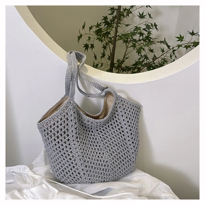 Close-up of gray hollow knit tote bag with soft texture and beige inner fabric lining
