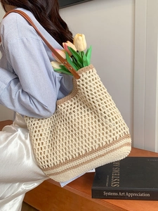Beige hollow crochet tote bag with brown leather shoulder strap for beach and casual use