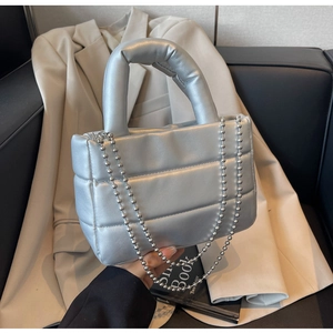 Detailed view of silver quilted bucket bag with metallic finish and beaded chain strap