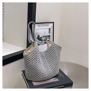 Detail of grey woven tote bag featuring hollow mesh pattern and beige cotton lining