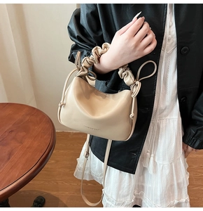 Detail of beige pleated shoulder bag with drawstrings and FASHION & BAGS text