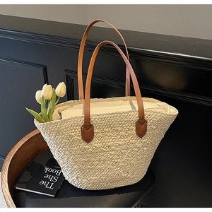 Macro detail of natural beige straw weave texture and brown leather straps on a beach bag