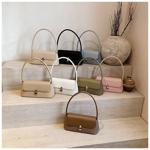 Collection de sacs portés épaule en plusieurs coloris sur des marches en pierre