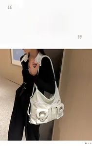 Detailed close-up of white multi-pocket functional tote bag with silver metal zippers
