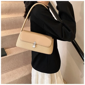 Détail du sac sous le bras tendance montrant le cuir et la paille tressée contrastés