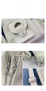 Detail of cream tote bag with dual metal zippers, silver hardware, and adjustable straps