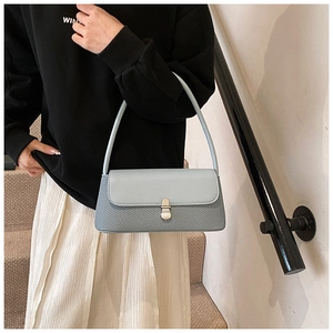Détail du rabat en cuir bleu clair et de la texture tissée du sac sous l'aisselle