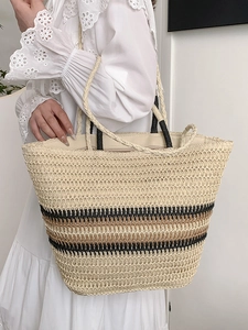 Large woven tote bag with tricolor stripes and top handles for beach or travel use