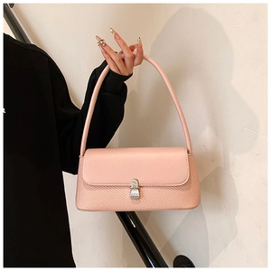 Détail du sac sous le bras rose avec texture tissée et boucle incrustée de diamants