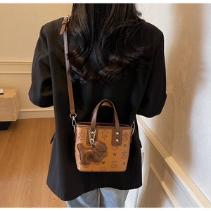 Sac seau gaufré marron à la mode porté en bandoulière sur une tenue décontractée