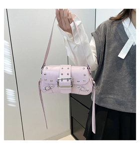 Detail of light pink Y2K shoulder bag with silver rivets and long leather tassels