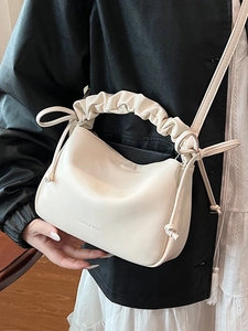 Minimalist beige ruched pillow bag with cloud-style handle and side drawstring details