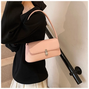 Gros plan du sac sous le bras en cuir tressé rose avec boucle argentée sur mannequin