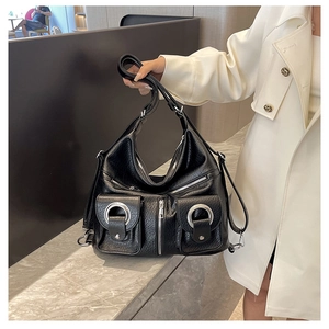 Close-up of black pebble leather tote with silver ring hardware and cargo pockets