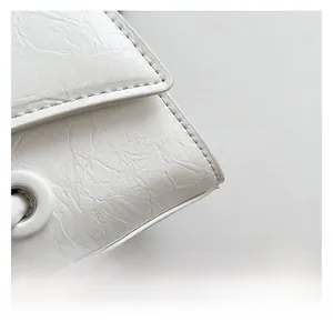 Detailed close-up of premium white pleated texture fabric and refined stitching on handbag