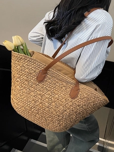 Large hand-woven straw tote bag with brown leather handles for summer beach vacations