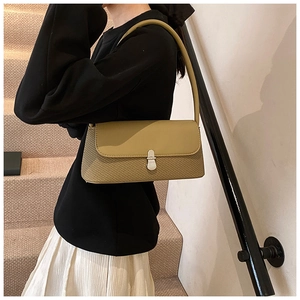 Détail d'un sac baguette vert olive avec texture tressée et boucle en métal argenté