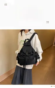 Detail view of the black casual backpack with flap buckle and side zipper pockets