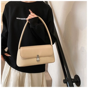 Détail du sac sous le bras beige clair avec texture tissée et boucle en métal argenté