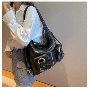 Detailed side view of black PU leather hobo bag with silver rings and multiple zippers