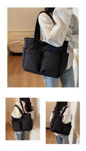 Detail of black nylon tote bag showing spacious multi-pocket design and strap detail