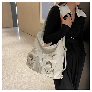 Detail of cream multi-pocket tote bag with pebbled leather and silver hardware details