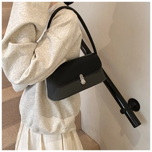 Sac à bandoulière minimaliste noir en cuir et tissu tissé avec fermoir argenté
