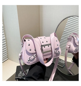 Détail du sac bandoulière punk rose avec clous argentés et boucle métallique en scène