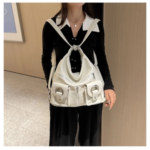 Close-up of cream white lychee texture leather with large metal ring flip pockets and zippers