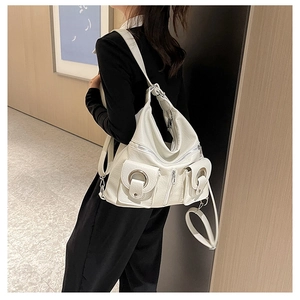 Detail view of the white PU leather tote bag featuring silver ring buckles and side pockets
