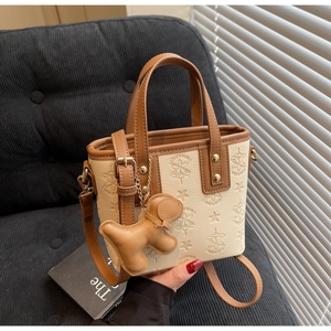 Détails du gaufrage sur sac seau blanc avec poignées en cuir et charm chien mignon