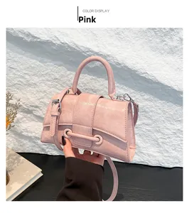 Close-up of pink textured PU leather handbag with dual ring metallic buckle detail