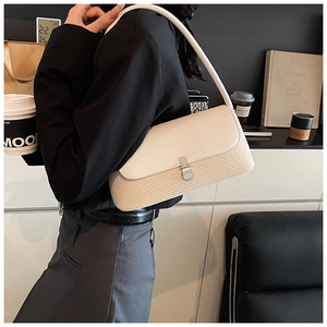 Détail du sac sous le bras en cuir crème et paille tressée avec boucle en métal