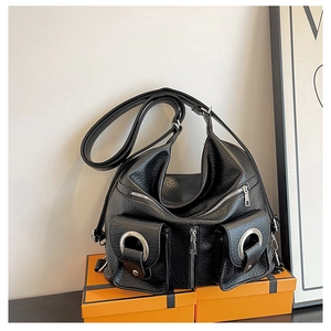 Detailed macro view of black pebbled leather tote bag with silver rings and zip pockets
