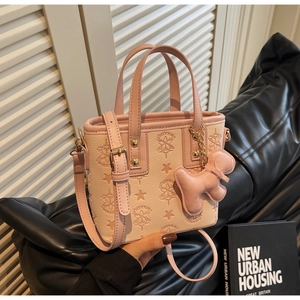 Détail d'un sac seau rose gaufré avec motifs d'étoiles et charmant petit ours